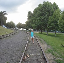 Criança correndo entre os trilhos do trem no Parque Central