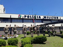 Policiais militares prestando continência às bandeiras no 15º BPM, em Caçador