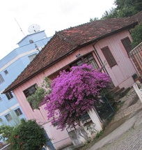 "Envio esta foto de uma casa antiga localizada na Rua Vida Ramos, destacando a integração de cores com a natureza"